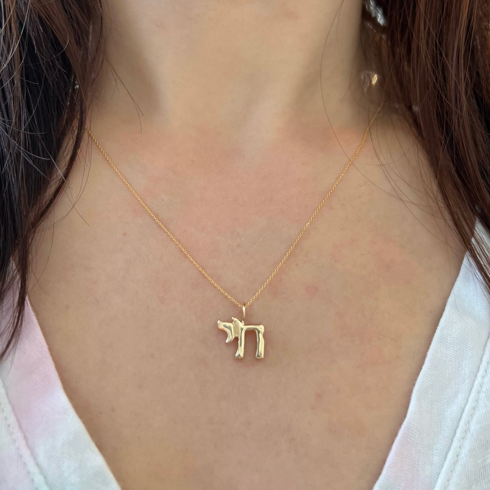 wearing the 14k yellow gold chai symbol charm necklace