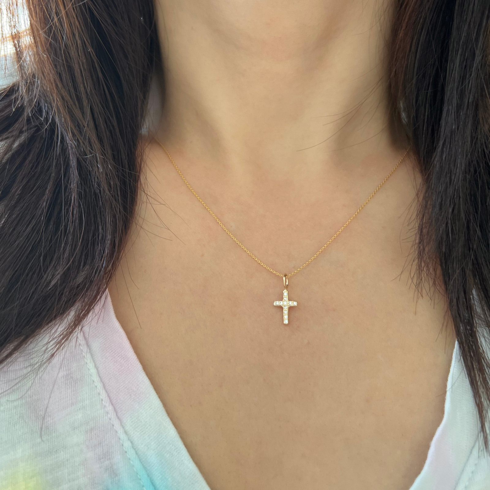 wearing the gold cross charm in 14k yellow gold with diamonds
