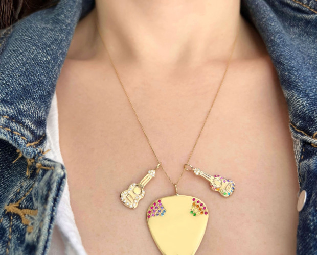 Wearing a necklace with the new rainbow colored gemstone 14k yellow gold guitar charm, the rainbow colored 14k yellow gold guitar pick charm, and another 14k yellow gold guitar charm with white diamonds