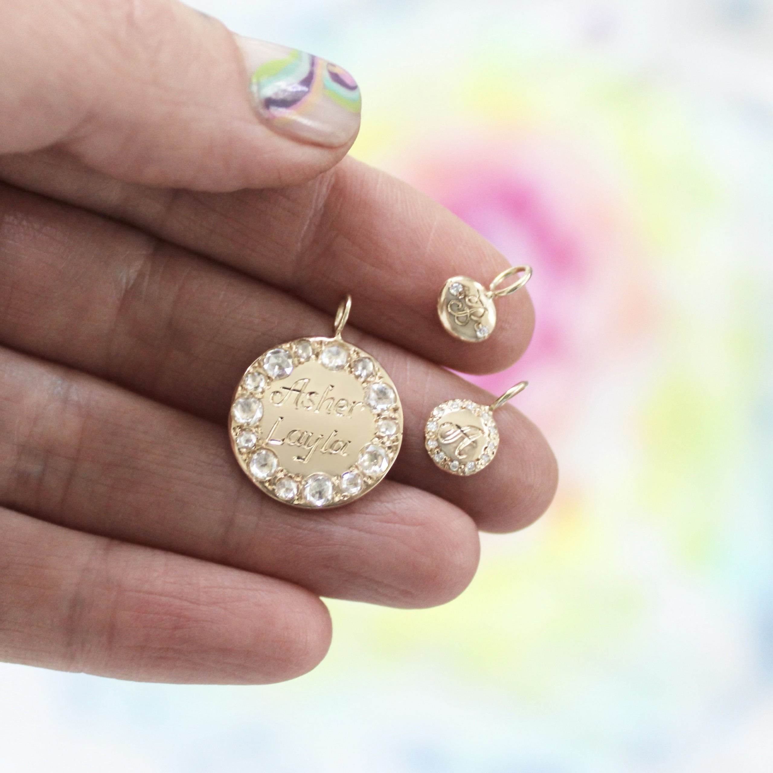 holding the three new engraved charms