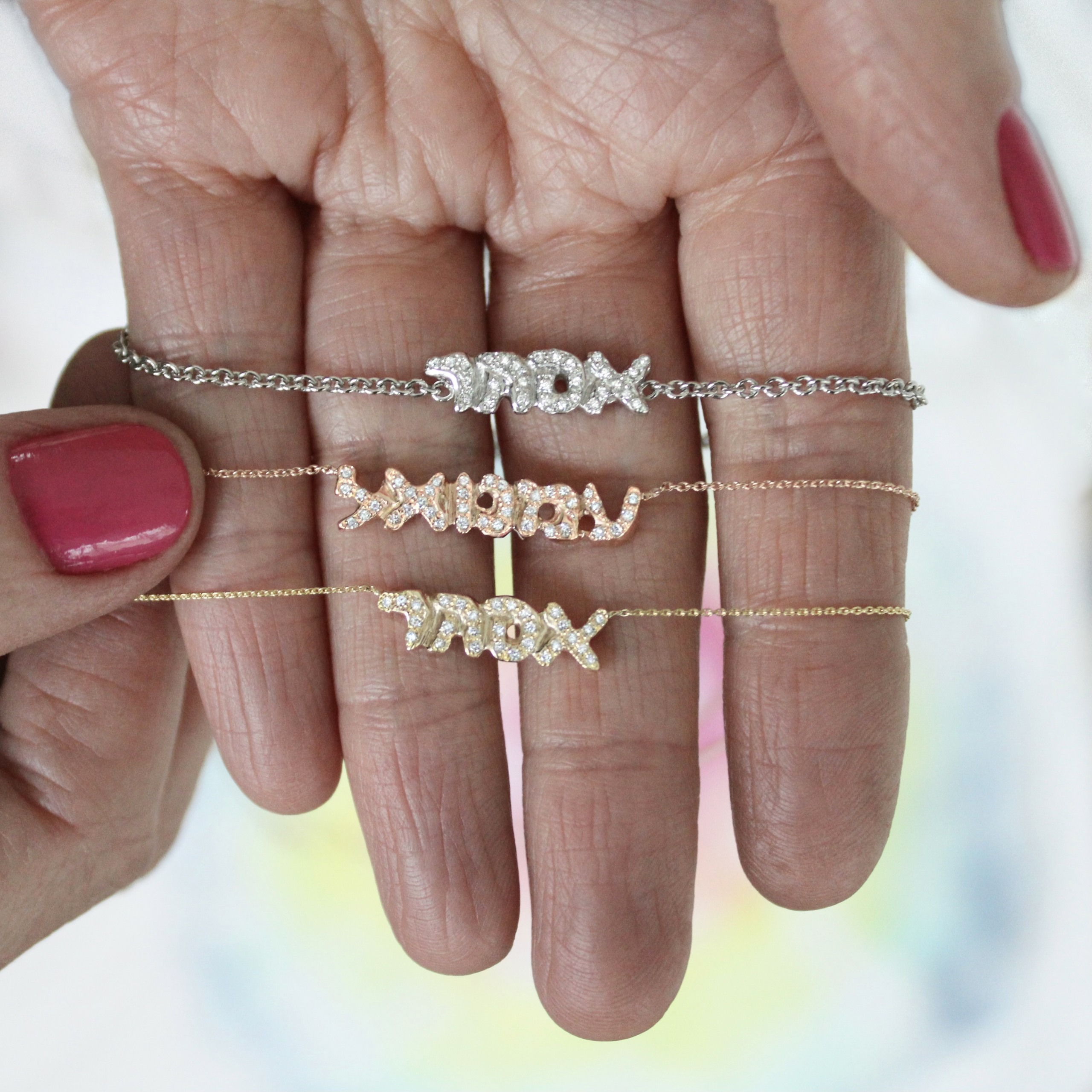 hebrew-gold-diamond-name-bracelets holding the gold and diamond hebrew name bracelets