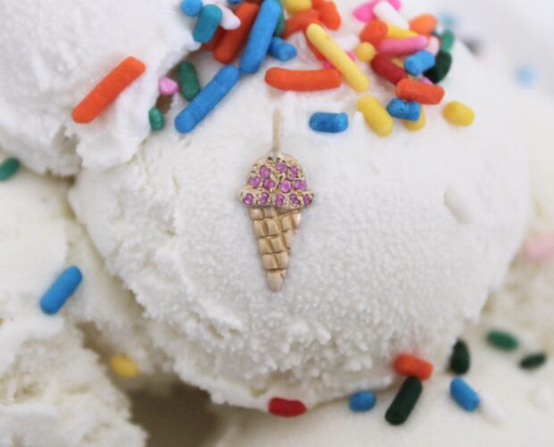 gold ice cream cone charm with pink diamonds on top of an ice cream scoop with sprinkles