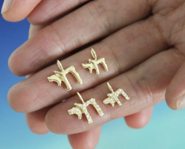 tiny chai symbol gold and diamond charms close-u holding in your hand